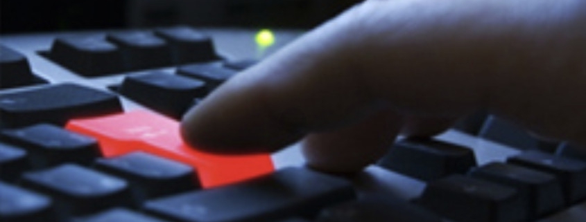 Computer keyboard with red enter key being pressed