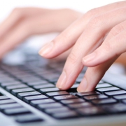 Hands typing on computer keyboard